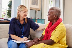 Worker speaking with older worker with questionnaire during intake.